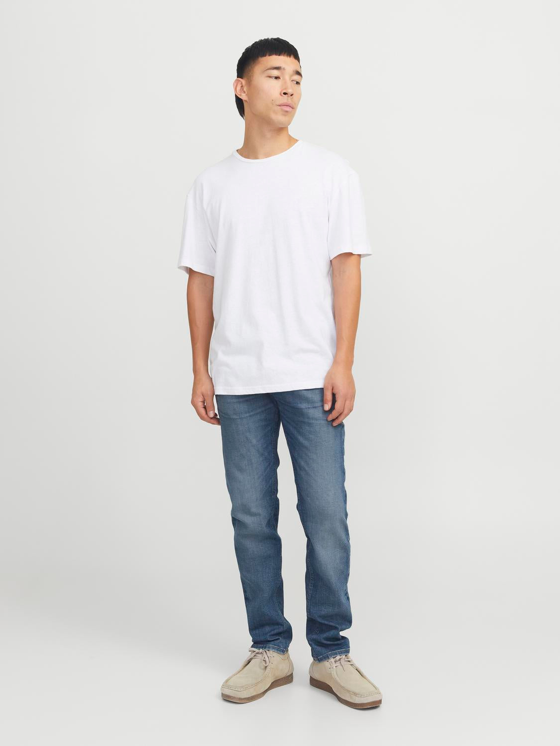 شخص يرتدي بنطلون جينز جيجيمايك الأزرق مع تيشيرت أبيض، يعكس إطلالة عصريّة ومريحة