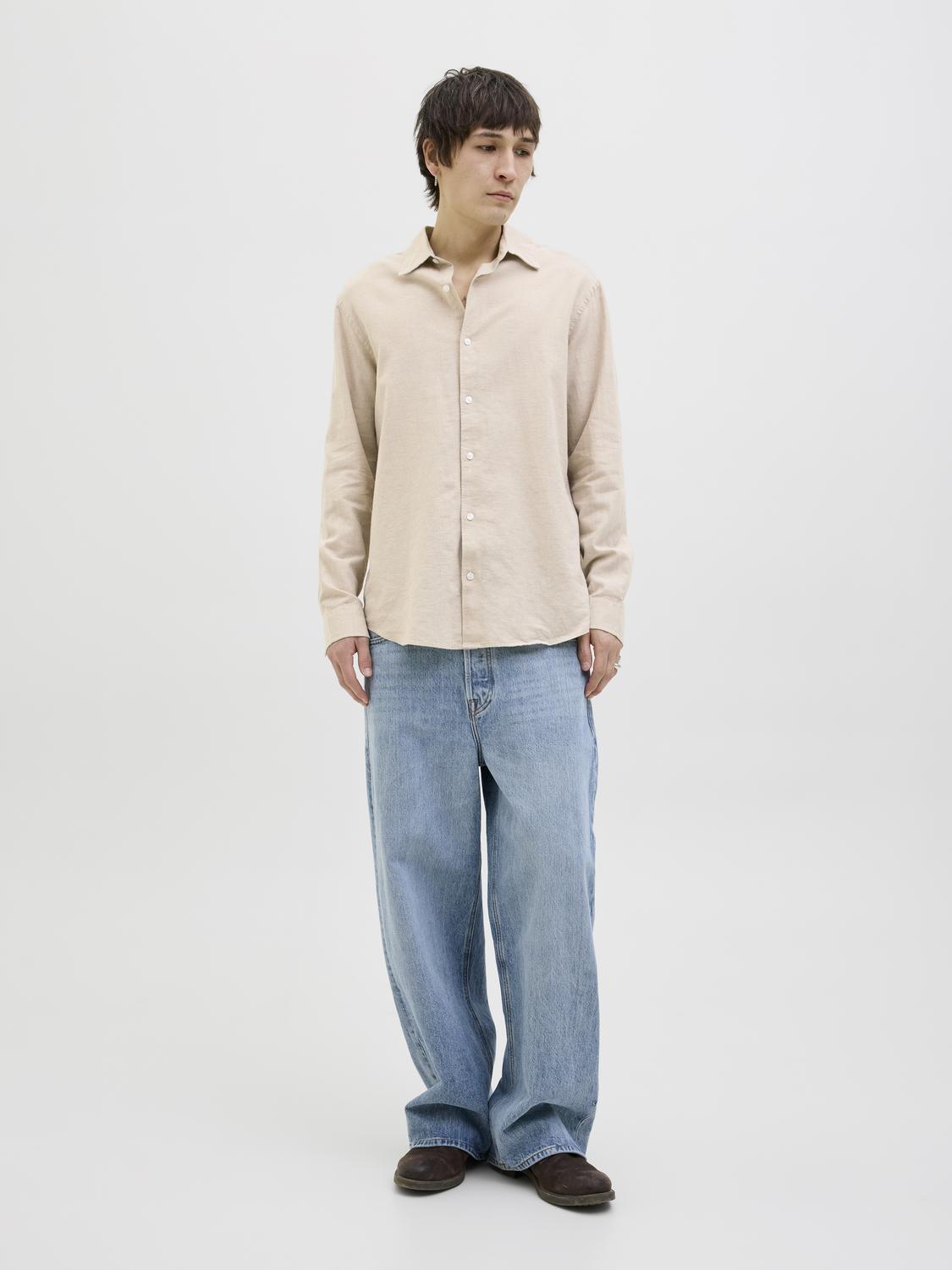 قميص رجالي بيج بأكمام طويلة – موديل واقف أمام الكاميرا