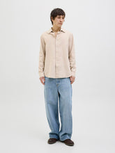 قميص رجالي بيج بأكمام طويلة – موديل واقف أمام الكاميرا