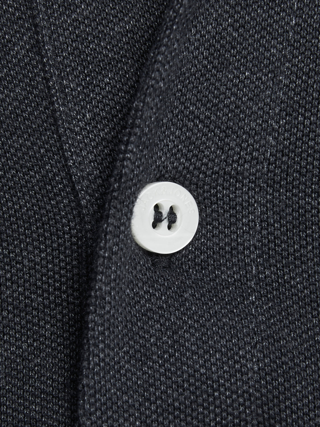 لقطة مقربة لزر التيشيرت وتفاصيل خامته