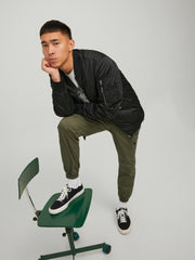 رجل يرتدي البنطلون الأخضر الرياضي أثناء الحركة

