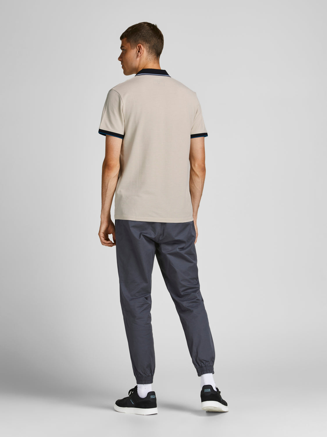 موديل يرتدي تيشيرت بولو موون بيم مع سروال كاجوال رمادي