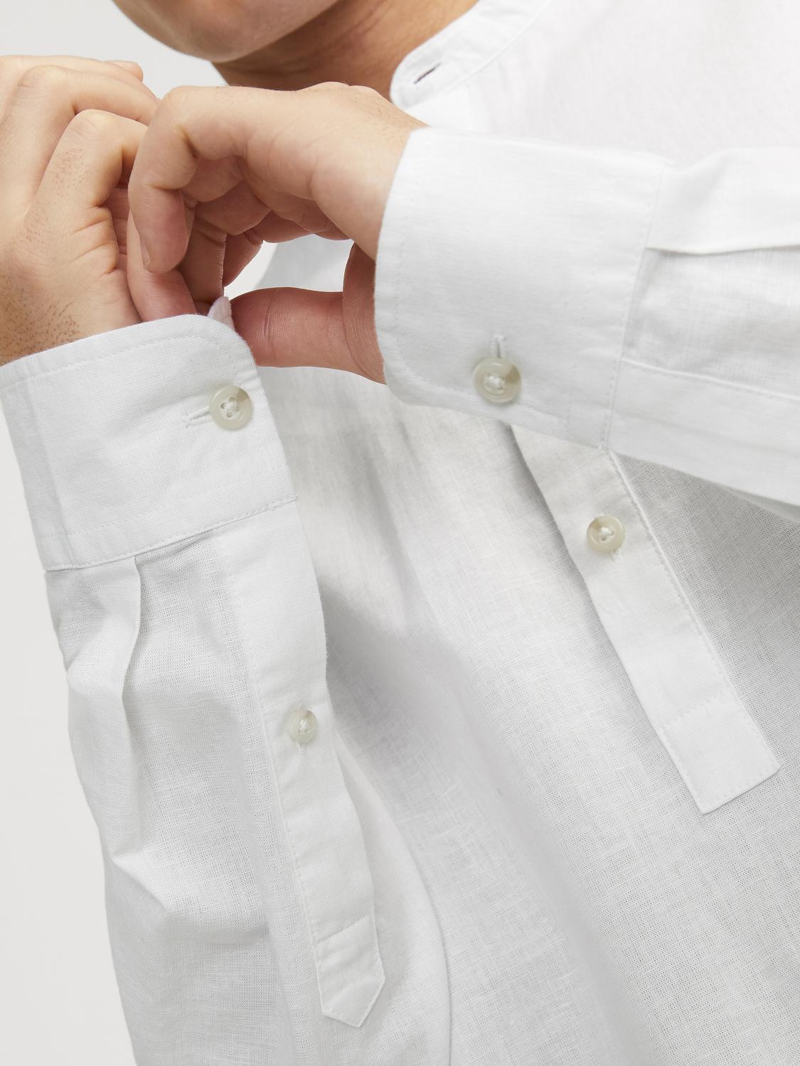لقطة مقربة تُظهر طرف أكمام قميص رجالي أبيض بأكمام طويلة مع زر صغير عند المعصم.