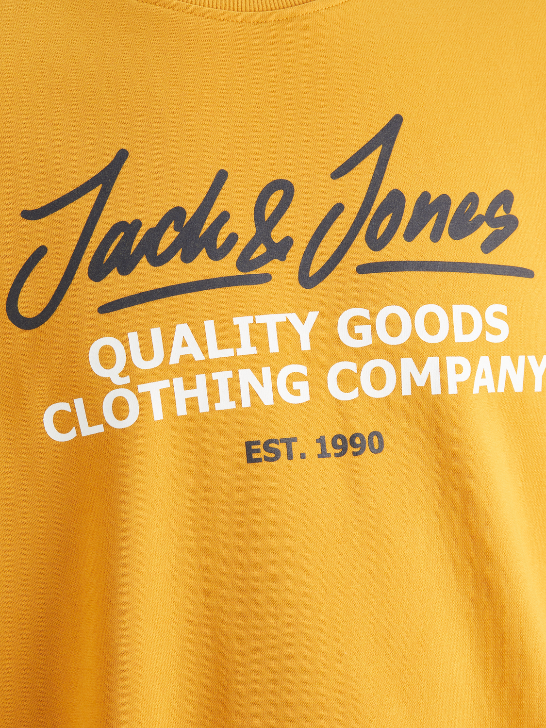 صورة قريبة تُظهر شعار Jack & Jones مطبوع على سويت شيرت ذهبي رجالي.