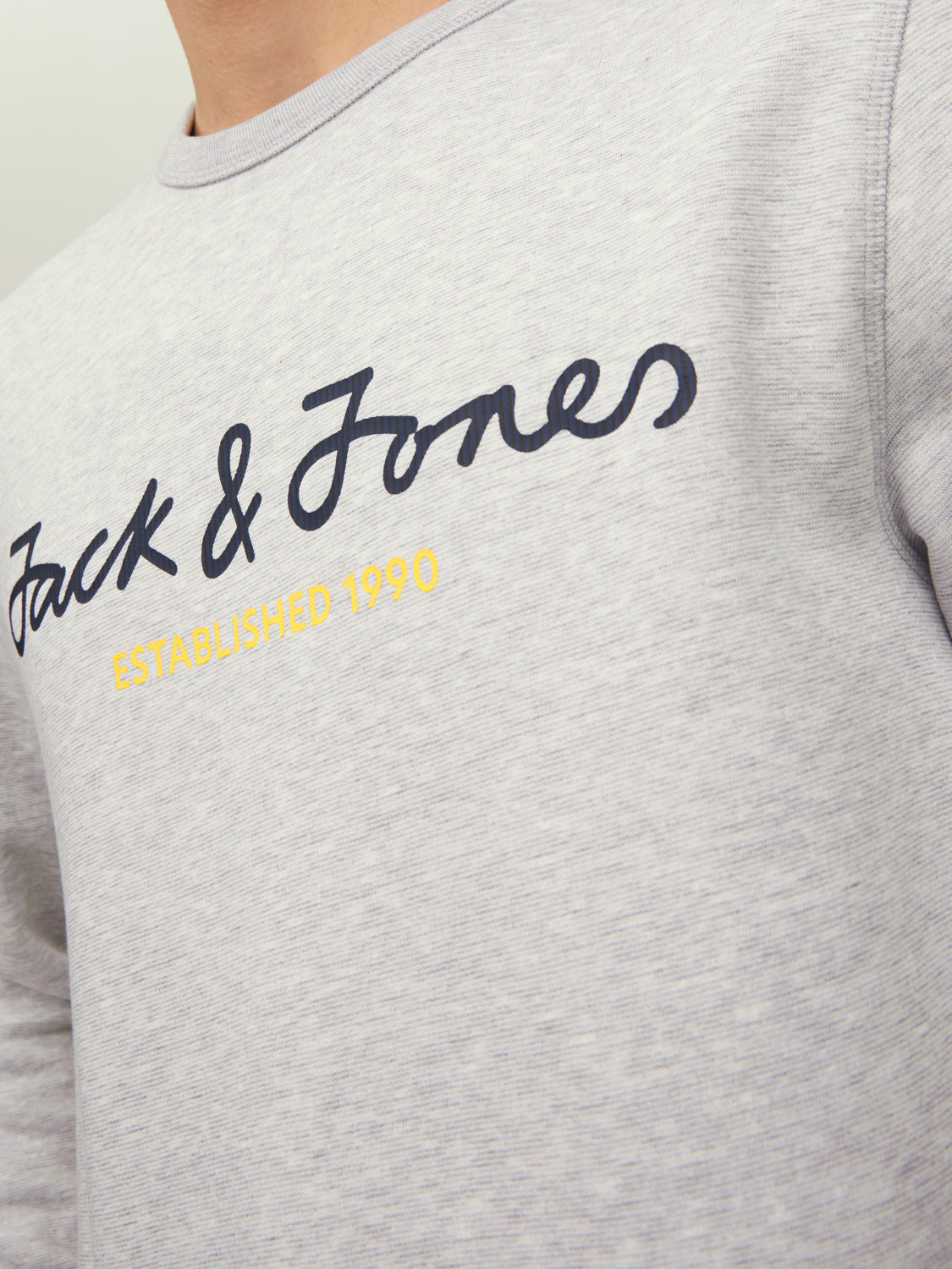 سويت شيرت رمادي فاتح – لقطة مقربة لتفاصيل الخامة والشعار