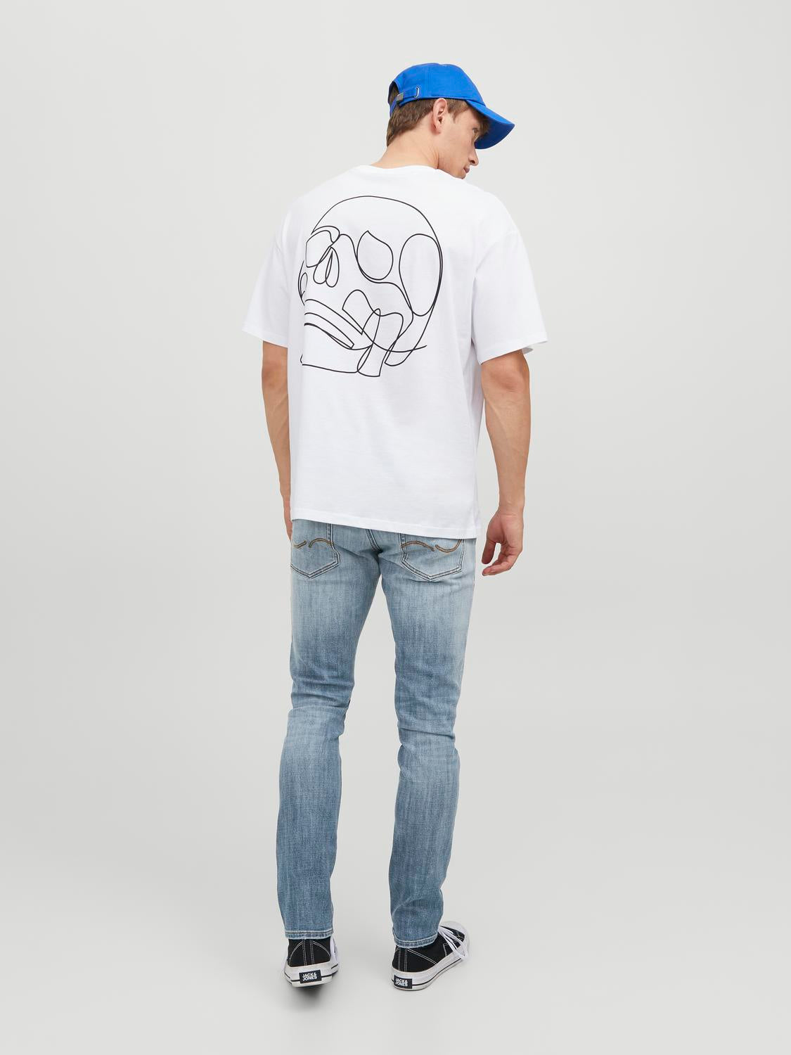 موديل يظهر من الخلف مع تيشيرت أبيض مطبوع لإبراز تصميم الجيوب