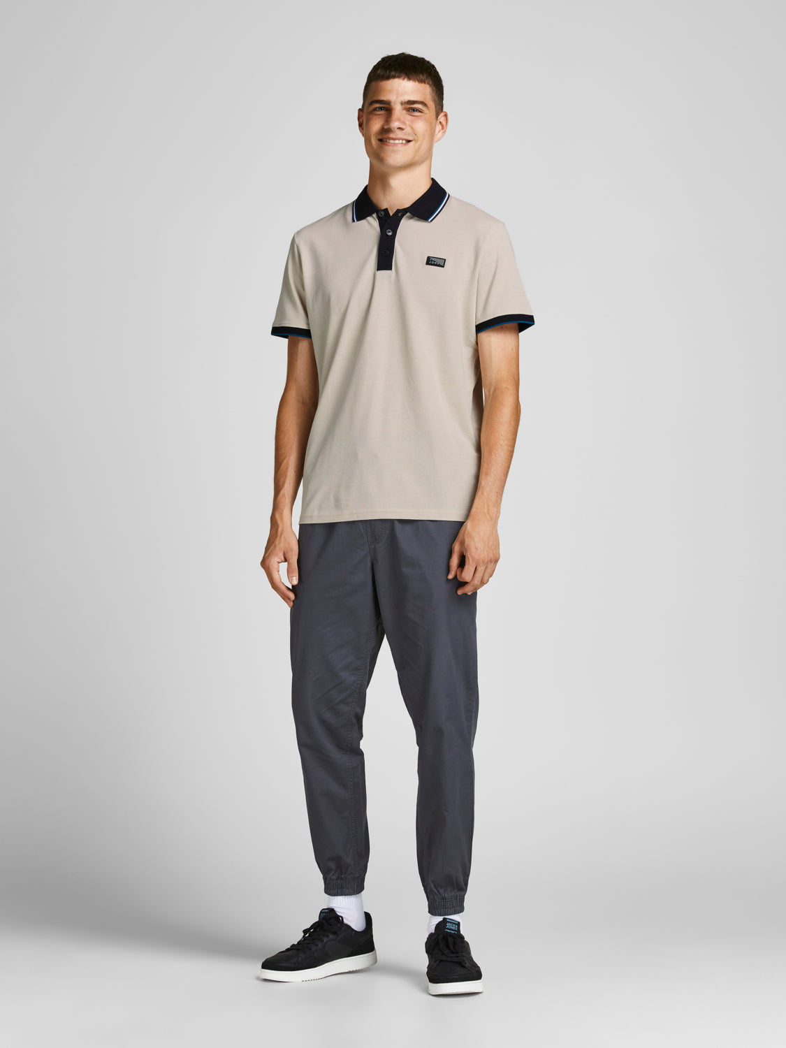موديل يرتدي تيشيرت بولو موون بيم مع سروال كاجوال رمادي
